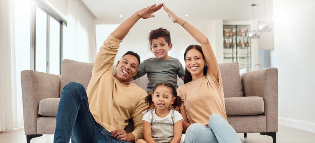 Happy family in front of their insured home